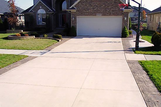 Concrete driveway in front of house with garage.